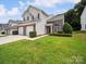 Two-story townhome featuring a well-maintained lawn and a two-car garage at 12415 Stratfield Place Cir, Pineville, NC 28134