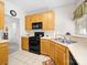Functional kitchen features light wood cabinets, black appliances, and ample counter space with tile floor at 12415 Stratfield Place Cir, Pineville, NC 28134