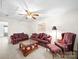 Traditional living room features plush seating, a ceiling fan, and carpeted floors at 12415 Stratfield Place Cir, Pineville, NC 28134