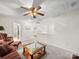 A view of the living room with a ceiling fan and a coffee table at 12415 Stratfield Place Cir, Pineville, NC 28134