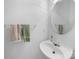 Clean powder room featuring neutral paint, a modern sink, a round mirror, and towel racks at 12415 Stratfield Place Cir, Pineville, NC 28134