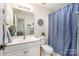 Bright bathroom with a single vanity, toilet, shower with blue curtain, and tasteful decor at 138 Blandina Ct, Fort Mill, SC 29708