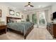 Bright bedroom featuring a large bed, carpeted floor, ceiling fan, and large windows that let in plenty of natural light at 138 Blandina Ct, Fort Mill, SC 29708