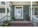 Inviting front porch with rocking chair, plants and view of the two-car garage of this charming two-story home at 138 Blandina Ct, Fort Mill, SC 29708