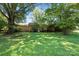 Lush backyard featuring a large shade tree and green lawn creating a serene and private outdoor space at 13909 Idlewild Rd, Matthews, NC 28105