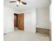 Well-lit bedroom with neutral carpet and closet for storage, with adjacent bathroom at 13909 Idlewild Rd, Matthews, NC 28105