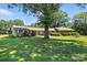 Spacious front yard with lush green lawn and mature shade trees enhancing curb appeal on a sunny day at 13909 Idlewild Rd, Matthews, NC 28105