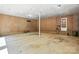View of a spacious garage with storage shelving, paneled walls, concrete flooring, and access to the exterior at 13909 Idlewild Rd, Matthews, NC 28105