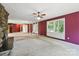 Spacious living room featuring a stone fireplace, neutral carpet, large windows with natural light, and red wallpaper at 13909 Idlewild Rd, Matthews, NC 28105
