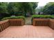 Wooden deck with railings overlooking a green backyard with manicured hedges at 1409 Turner Dr, Gastonia, NC 28052