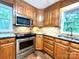 Updated kitchen featuring wood cabinets, granite countertops, stainless steel appliances, and stylish backsplash at 143 Uwharrie Ct # 10801081, Mount Gilead, NC 27306