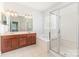 Bright bathroom with a glass shower, a soaking tub, a double vanity, and tile flooring at 14333 Maclauren Ln, Huntersville, NC 28078