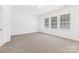 Neutral bedroom with carpet flooring, light colored walls, and large windows at 14333 Maclauren Ln, Huntersville, NC 28078