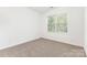 Sunlit carpeted bedroom with a window, offering a tranquil and airy atmosphere at 14333 Maclauren Ln, Huntersville, NC 28078