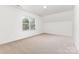 Carpeted bedroom with large window and sloped ceiling, offering natural light and a cozy atmosphere at 14333 Maclauren Ln, Huntersville, NC 28078