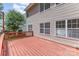 View of a red wooden deck against the side of a home with multi-paned windows at 14333 Maclauren Ln, Huntersville, NC 28078
