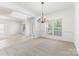Bright dining room featuring a chandelier, neutral carpeting, and views of the front yard through windows at 14333 Maclauren Ln, Huntersville, NC 28078