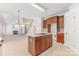 Spacious kitchen with wood cabinets, island, and open view into the carpeted living room and staircase at 14333 Maclauren Ln, Huntersville, NC 28078