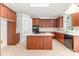 Well-lit kitchen features wood cabinetry, a tile backsplash, and an island with a white countertop at 14333 Maclauren Ln, Huntersville, NC 28078