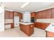 Bright kitchen boasts a kitchen island, wooden cabinetry, built-in appliances, and tile flooring, creating a culinary haven at 14333 Maclauren Ln, Huntersville, NC 28078