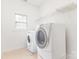 Well-lit laundry room with side-by-side washer and dryer units, and wire shelving at 14333 Maclauren Ln, Huntersville, NC 28078