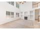 Bright living room boasting high ceilings, a fireplace with shelving, carpet, and large windows for ample natural light at 14333 Maclauren Ln, Huntersville, NC 28078