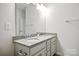 Bathroom featuring double sinks with granite countertops, a large mirror, and modern fixtures at 15119 Oleander Dr, Charlotte, NC 28278