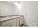 Bathroom with a double sink vanity with granite countertops, a large mirror, and modern fixtures at 15119 Oleander Dr, Charlotte, NC 28278