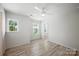 Bright bedroom with hardwood floors, ceiling fan, and natural light from two windows at 15119 Oleander Dr, Charlotte, NC 28278