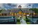 Community clubhouse featuring a clock tower, manicured landscaping and a tennis court at 15119 Oleander Dr, Charlotte, NC 28278