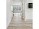 Hallway featuring light walls, and wood-look flooring leading to an open living area with natural light at 15119 Oleander Dr, Charlotte, NC 28278