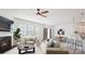 Open concept living room with fireplace, large windows, neutral colors, and modern furnishings at 15119 Oleander Dr, Charlotte, NC 28278