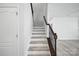 Staircase featuring white risers, wood-look treads, and a decorative railing leading to the upper level at 15119 Oleander Dr, Charlotte, NC 28278
