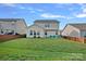 Large, grassy backyard showcasing the home's exterior and seating area at 1527 Scarbrough Sw Cir, Concord, NC 28025