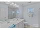 Bright bathroom featuring double sinks, a walk-in shower, and a window providing natural light at 1527 Scarbrough Sw Cir, Concord, NC 28025