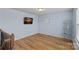 Light blue bonus room with wood floors, modern decor, and a tv on the wall by a staircase at 1527 Scarbrough Sw Cir, Concord, NC 28025