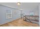 Bright and airy bonus room featuring wood floors, modern decor, and a staircase with wood and iron railing at 1527 Scarbrough Sw Cir, Concord, NC 28025