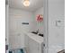 Neat laundry room with white washer and dryer, wire shelving, tile flooring, and blue carolina panthers decor at 1527 Scarbrough Sw Cir, Concord, NC 28025