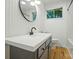 Modern bathroom with gray vanity, a round mirror, and white paneled walls offering a clean and stylish design at 1535 Maplewood Ave, Lancaster, SC 29720
