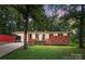 Charming brick home with a carport, well-maintained lawn, and mature trees offering ample shade and curb appeal at 1535 Maplewood Ave, Lancaster, SC 29720