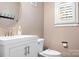 Half bathroom with a sleek vanity, modern fixtures, and neutral tones, illuminated by natural light at 15838 Trenton Place Rd, Huntersville, NC 28078