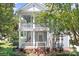 Charming two-story home with a welcoming double porch and light blue siding surrounded by lush landscaping at 15838 Trenton Place Rd, Huntersville, NC 28078