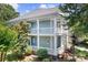 Charming two-story home featuring a double porch, light blue siding, and lush landscaping at 15838 Trenton Place Rd, Huntersville, NC 28078