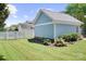 A detached garage sits behind a well-maintained lawn and features beautiful flower beds and a modern exterior at 15838 Trenton Place Rd, Huntersville, NC 28078