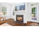 Cozy living room with a fireplace, hardwood floors, and large windows at 15838 Trenton Place Rd, Huntersville, NC 28078