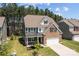 Beautiful home with brick and gray siding, an attached two-car garage, and a well-maintained lawn with beautiful landscaping at 169 Rooster Tail Ln, Troutman, NC 28166