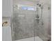 Bright bathroom featuring walk-in shower with glass door and grey tiles at 169 Rooster Tail Ln, Troutman, NC 28166