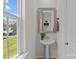 Powder room with pedestal sink, mirror, and a view of the outdoors through a window at 169 Rooster Tail Ln, Troutman, NC 28166