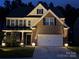 Well-lit two-story home featuring a brick facade and attached two-car garage, creating inviting curb appeal at 169 Rooster Tail Ln, Troutman, NC 28166