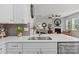 Close-up of the kitchen featuring white cabinets, quartz countertops, stainless steel sink and faucet at 169 Rooster Tail Ln, Troutman, NC 28166
